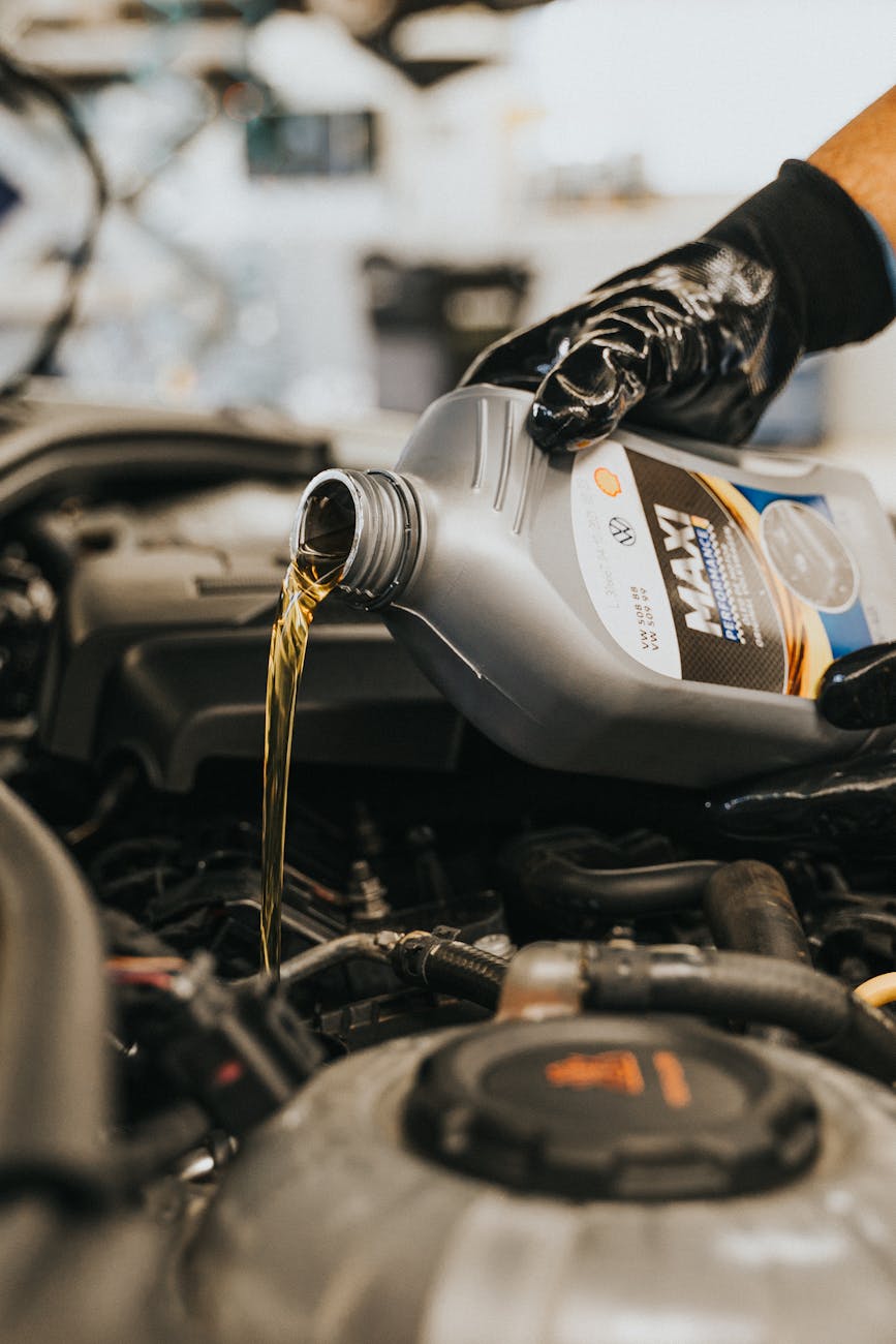 close up of hand pouring oil to engine